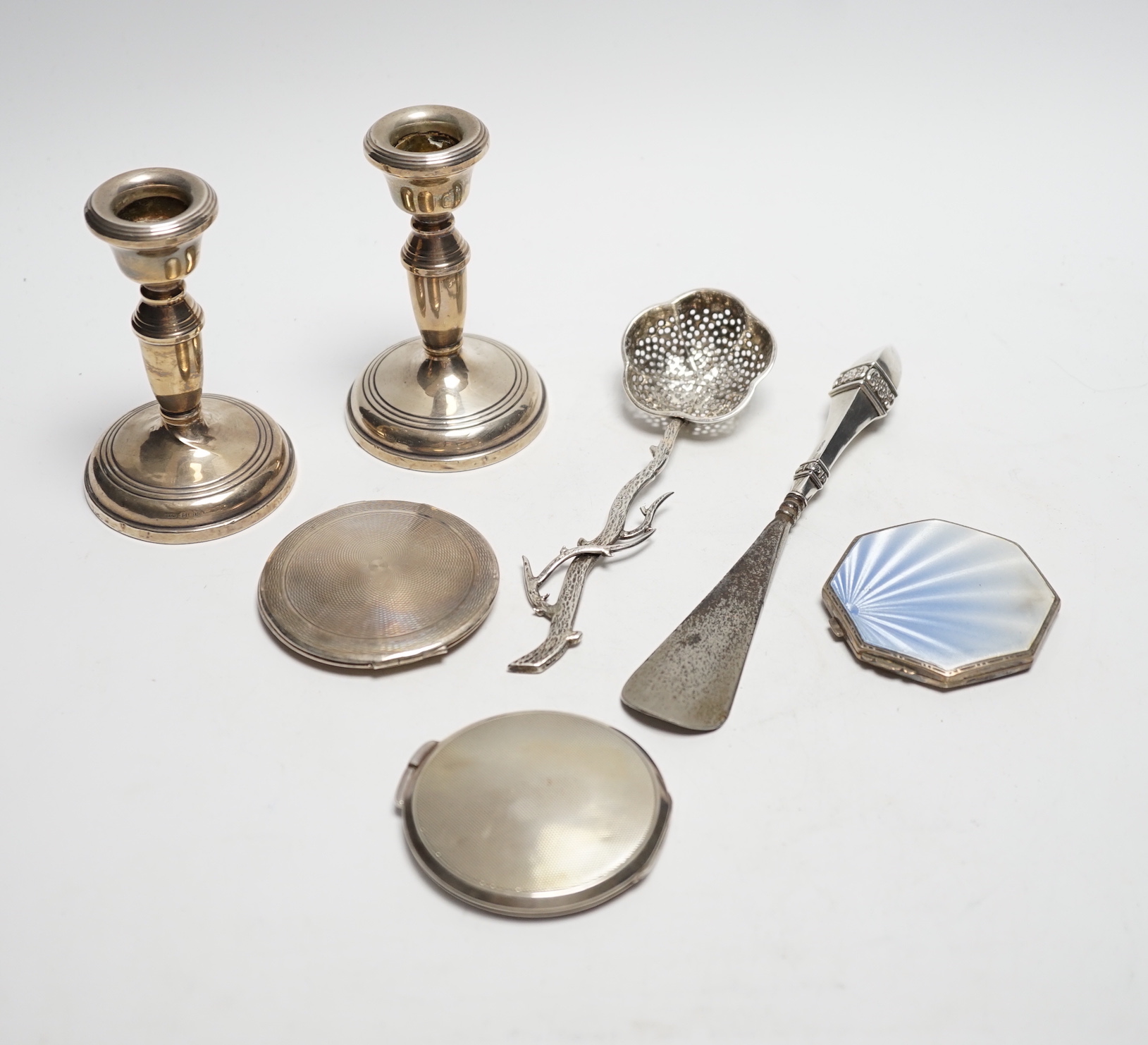 Three silver compacts including one enamelled, a pair of silver mounted dwarf candlesticks, 10.2cm and two other items.